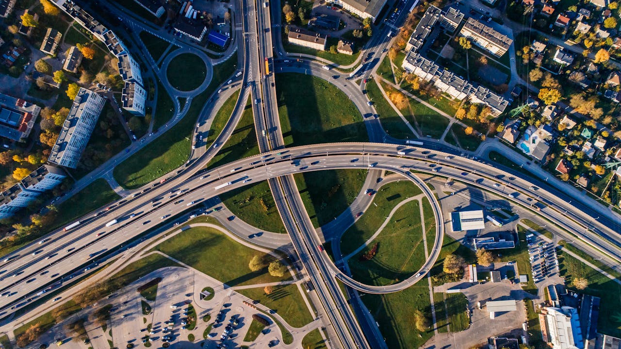Home Aerial shot of a complex highway intersection in a vibrant urban cityscape.